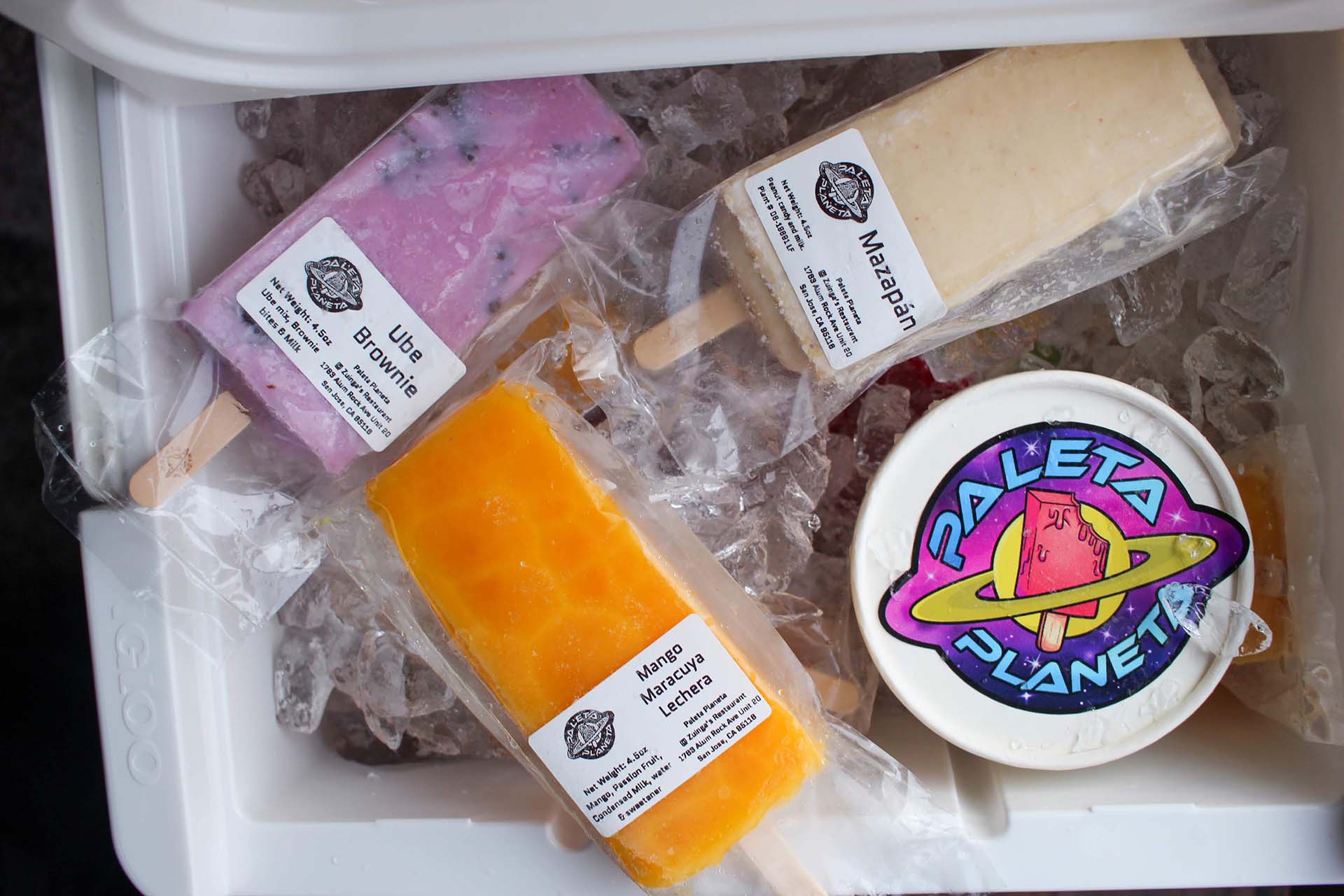 Ube brownie, mango maracuya lechera, mazapán paletas in a cooler.