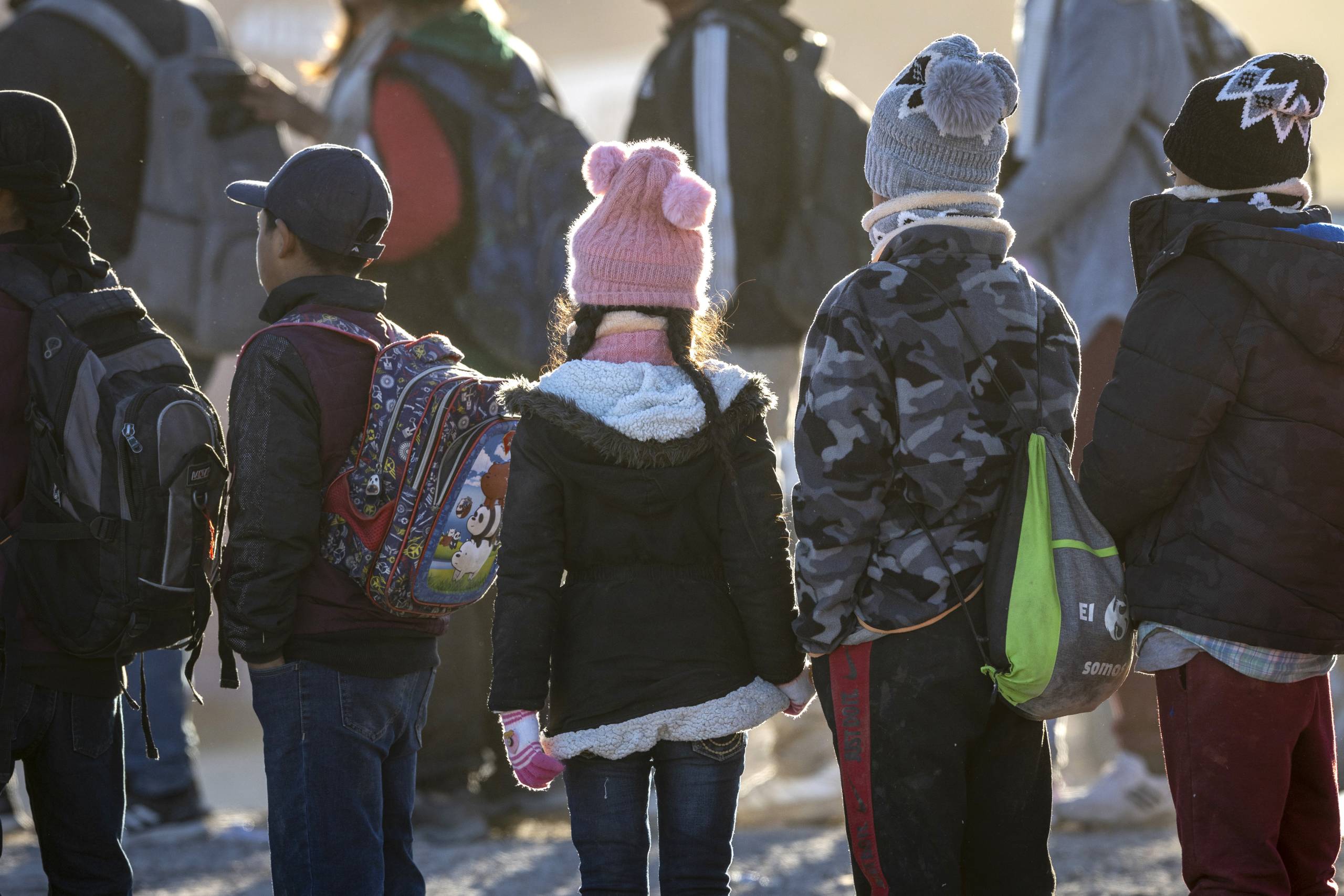 a line of kids outside in the desert