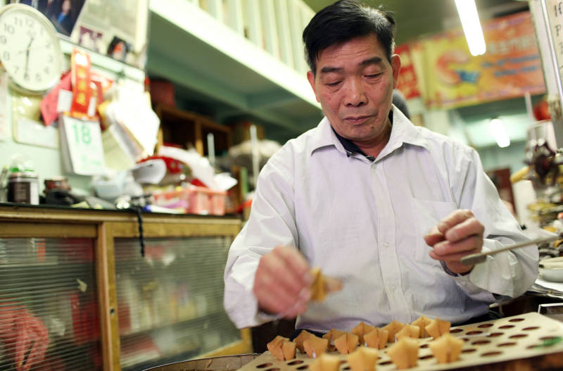 A worker makes fortune cookies at the Golden Gate Fortune Cookie Factory in San Francisco in 2012.